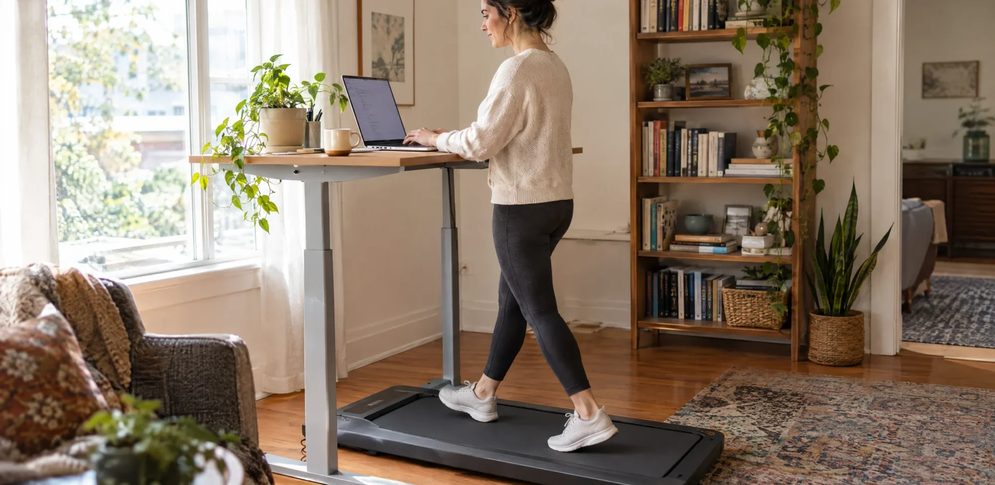A woman walking on a walking pad under a standing desk in her home office